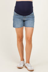 woman wearing a navy maternity tank top and distressed denim maternity shorts with a visible baby bump