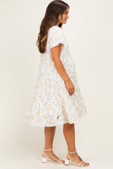 woman wearing a floral print maternity dress with short sleeves and a flowing skirt, showing her baby bump
