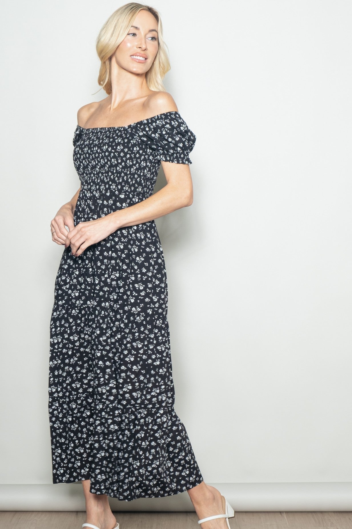woman wearing a black off-the-shoulder floral maxi dress with short puff sleeves and a fitted bodice