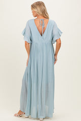 woman wearing a light blue maternity maxi dress with flutter sleeves and a tie-back design