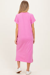 woman wearing a pink maternity dress with short sleeves and side slits, showing the back view