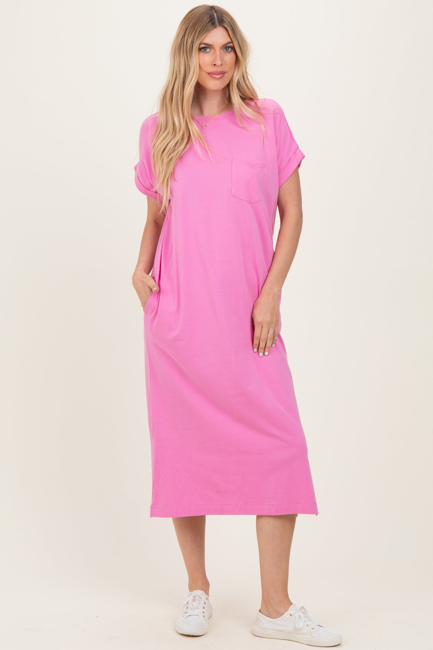 woman wearing a vibrant pink short sleeve midi dress with a pocket and side pockets