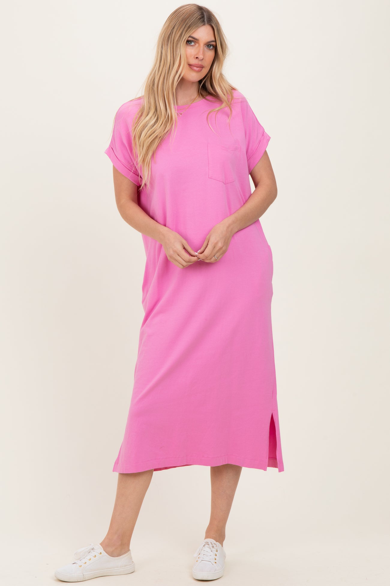 woman wearing a bright pink oversized t-shirt dress with short sleeves and a side slit
