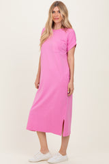 woman wearing a bright pink short sleeve maxi dress with a side slit and a pocket on the chest