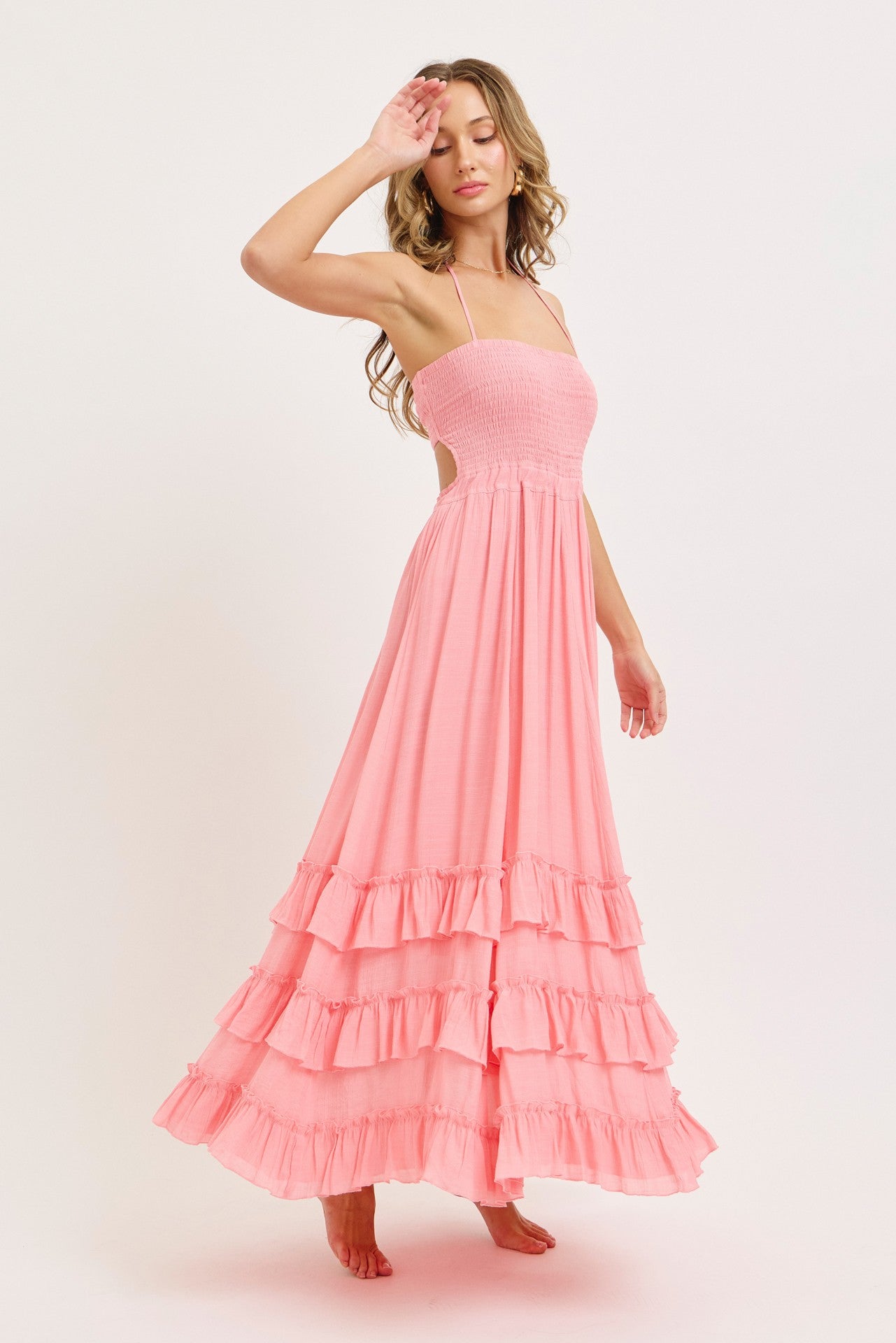 woman wearing a light pink tiered maxi dress with smocked bodice and spaghetti straps