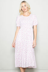 woman wearing a pink floral midi dress with short puff sleeves and a fitted bodice