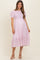 woman wearing a pink floral maternity dress with puff sleeves and a tiered skirt, showcasing a baby bump