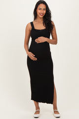 woman wearing a black maternity maxi dress with lace details and holding her baby bump