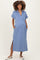 woman wearing a light blue maternity dress with a collared neckline and side pockets, showing off her baby bump