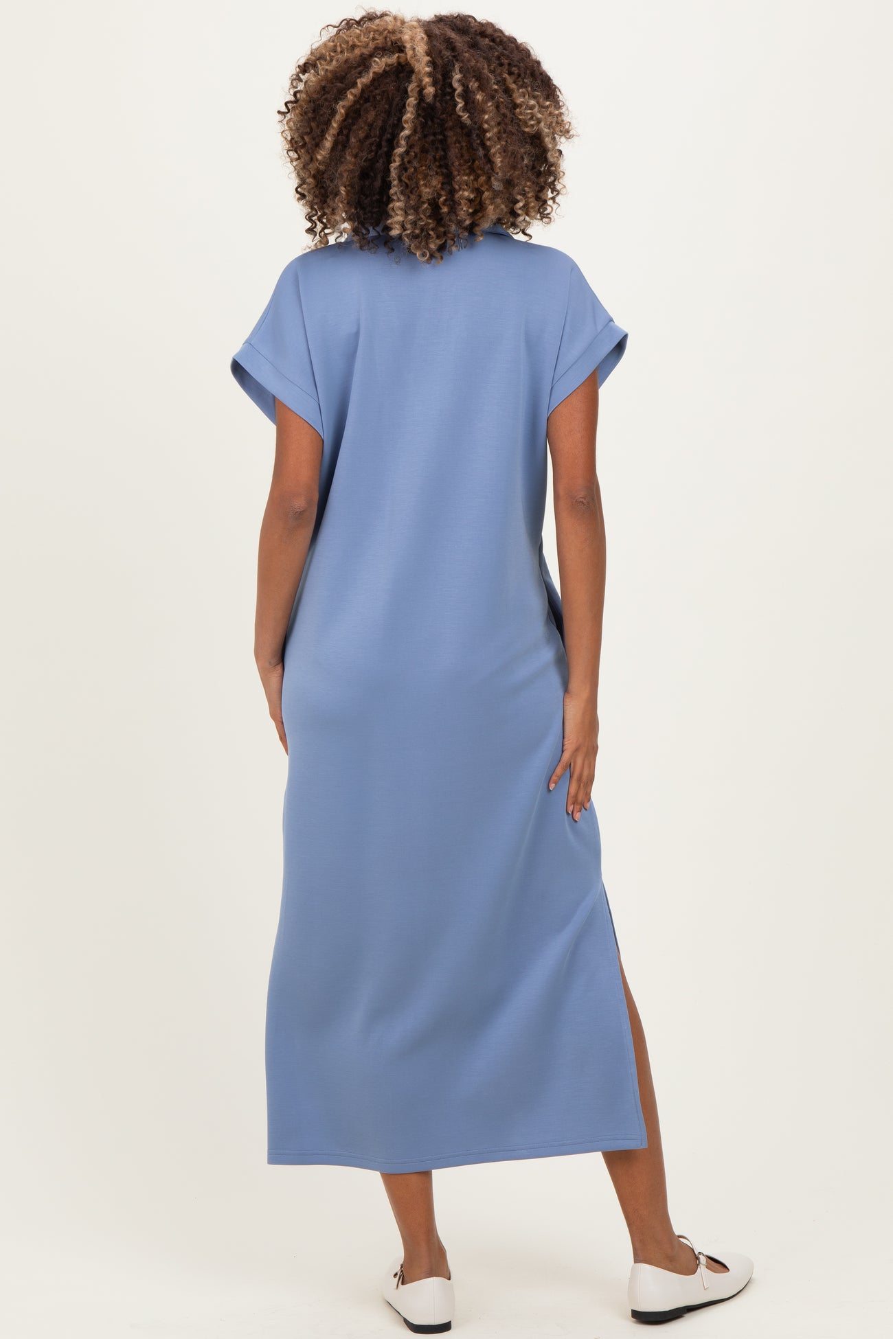 woman wearing a blue maternity maxi dress with short sleeves and side slits, shown from the back