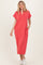 woman wearing a coral short sleeve maxi dress with a v-neck and pockets, standing and smiling