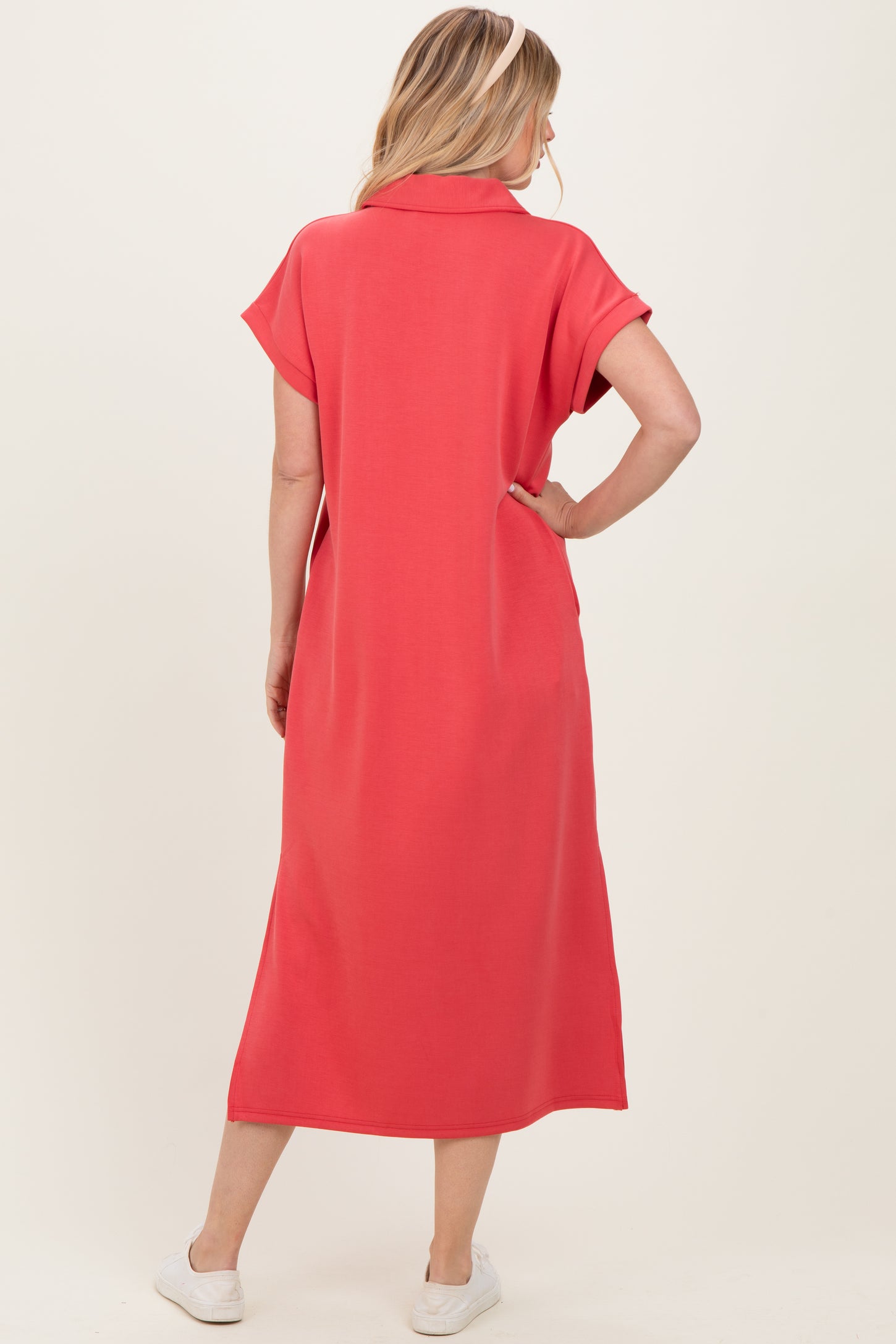 woman wearing a coral short sleeve maxi dress with a collar and side pockets, viewed from the back