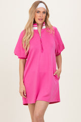 woman wearing a bright pink oversized polo dress with a zip neck and short sleeves