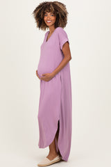 woman wearing a lavender maternity maxi dress with side slits and holding her baby bump