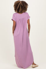 woman wearing a lavender maternity maxi dress with short sleeves and a relaxed fit, showing the back view