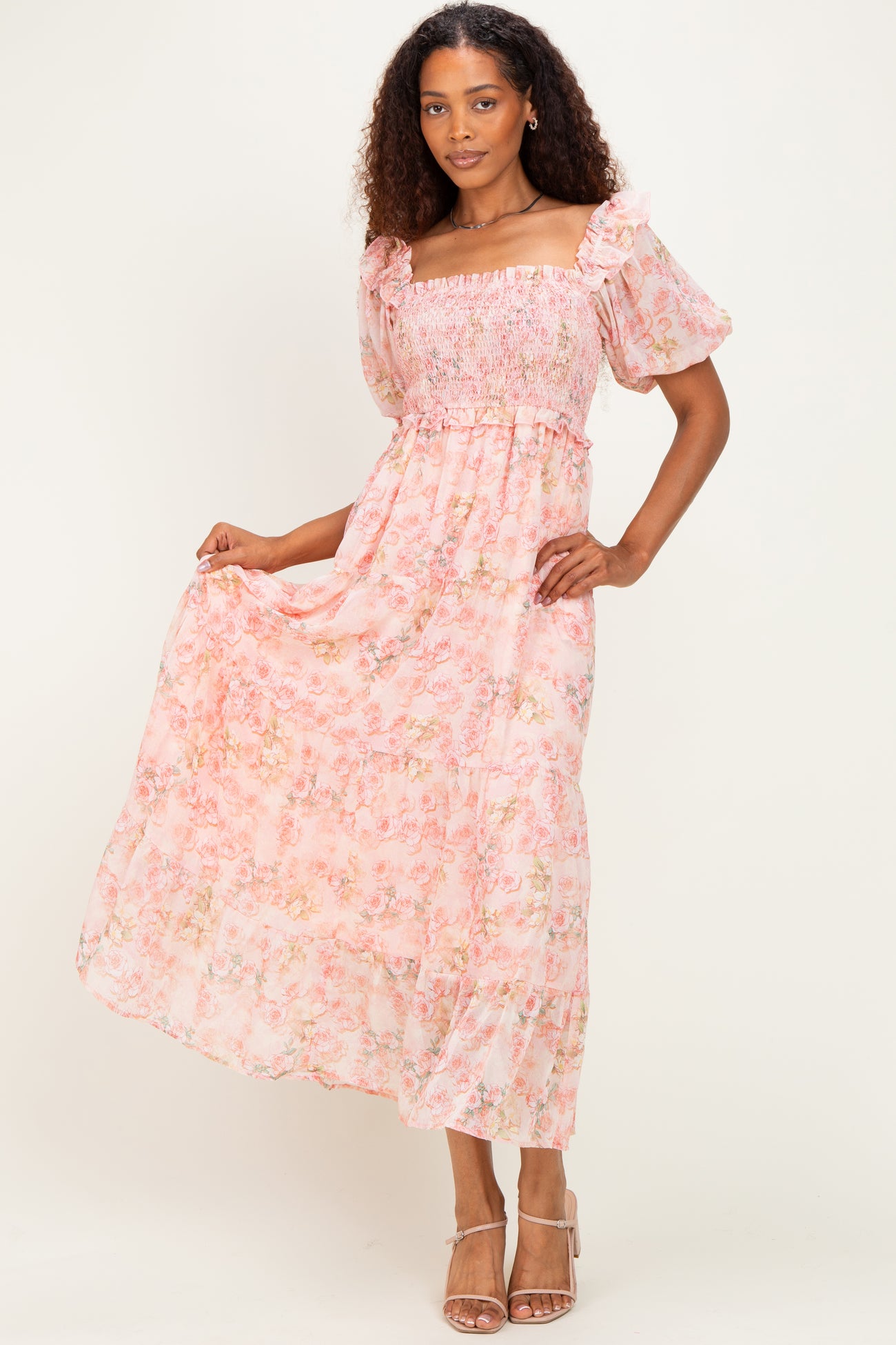 woman wearing a pink floral maxi dress with smocked bodice and puff sleeves