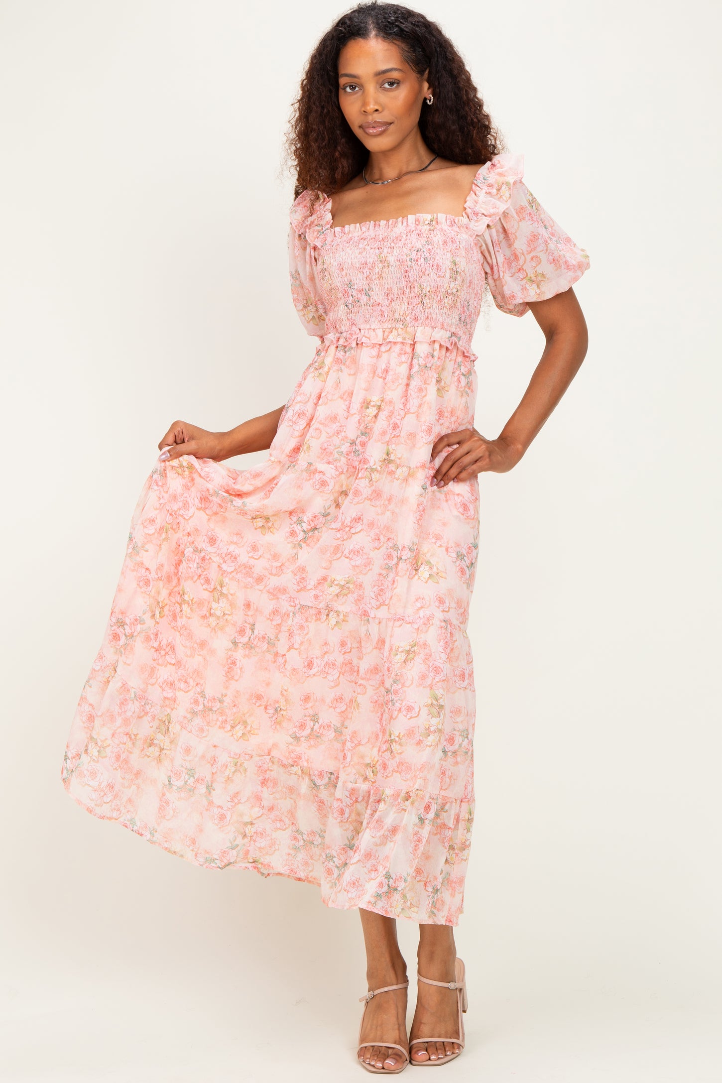 woman wearing a pink floral maxi dress with smocked bodice and puff sleeves