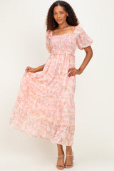 woman wearing a pink floral maxi dress with smocked bodice and puff sleeves