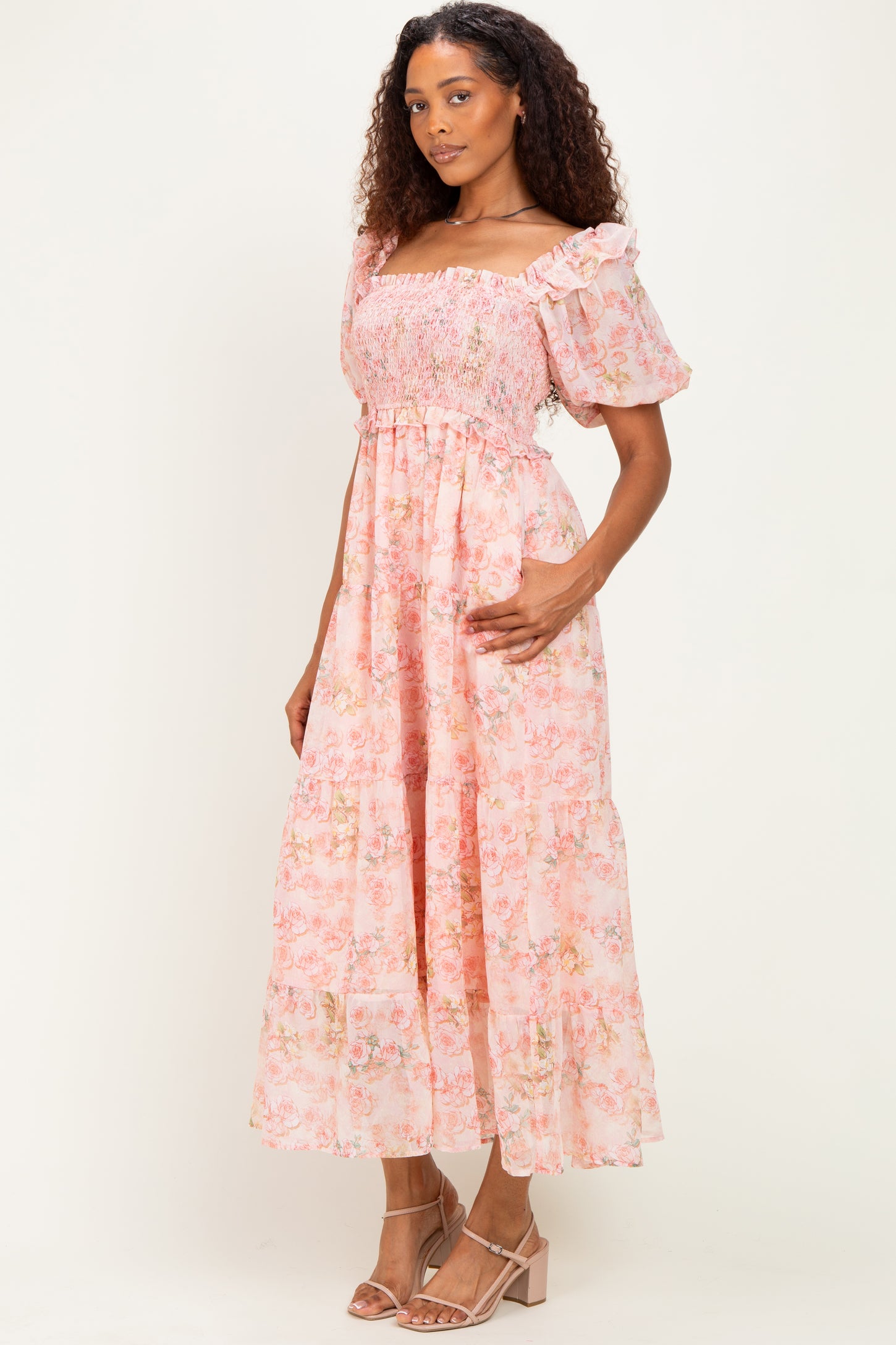 woman wearing a pink floral maxi dress with puff sleeves and a smocked bodice