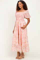 woman wearing a pink floral maxi dress with puff sleeves and a smocked bodice