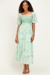 woman wearing a green floral maxi dress with short puff sleeves and smocked bodice