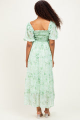 woman wearing a green floral maxi dress with short puff sleeves and a smocked bodice, viewed from the back