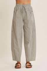 woman wearing black and white striped wide-leg pants with an elastic waistband and side pockets