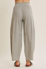 woman wearing gray and white striped wide leg pants with an elastic waistband, view of the back