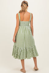 woman wearing a green and white checkered maternity dress with a smocked back and ruffle hem