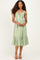 woman wearing a green and white gingham midi dress with a tiered ruffle hem and adjustable straps