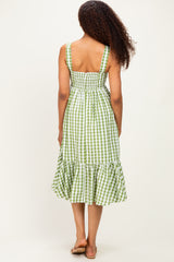 woman wearing a green and white gingham midi dress with smocked bodice and ruffled hem, seen from the back