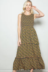 woman wearing a sleeveless floral maxi dress with tiered ruffles in yellow and green shades