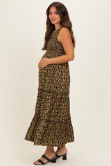 woman wearing a black floral maternity maxi dress with tiered skirt and holding her baby bump