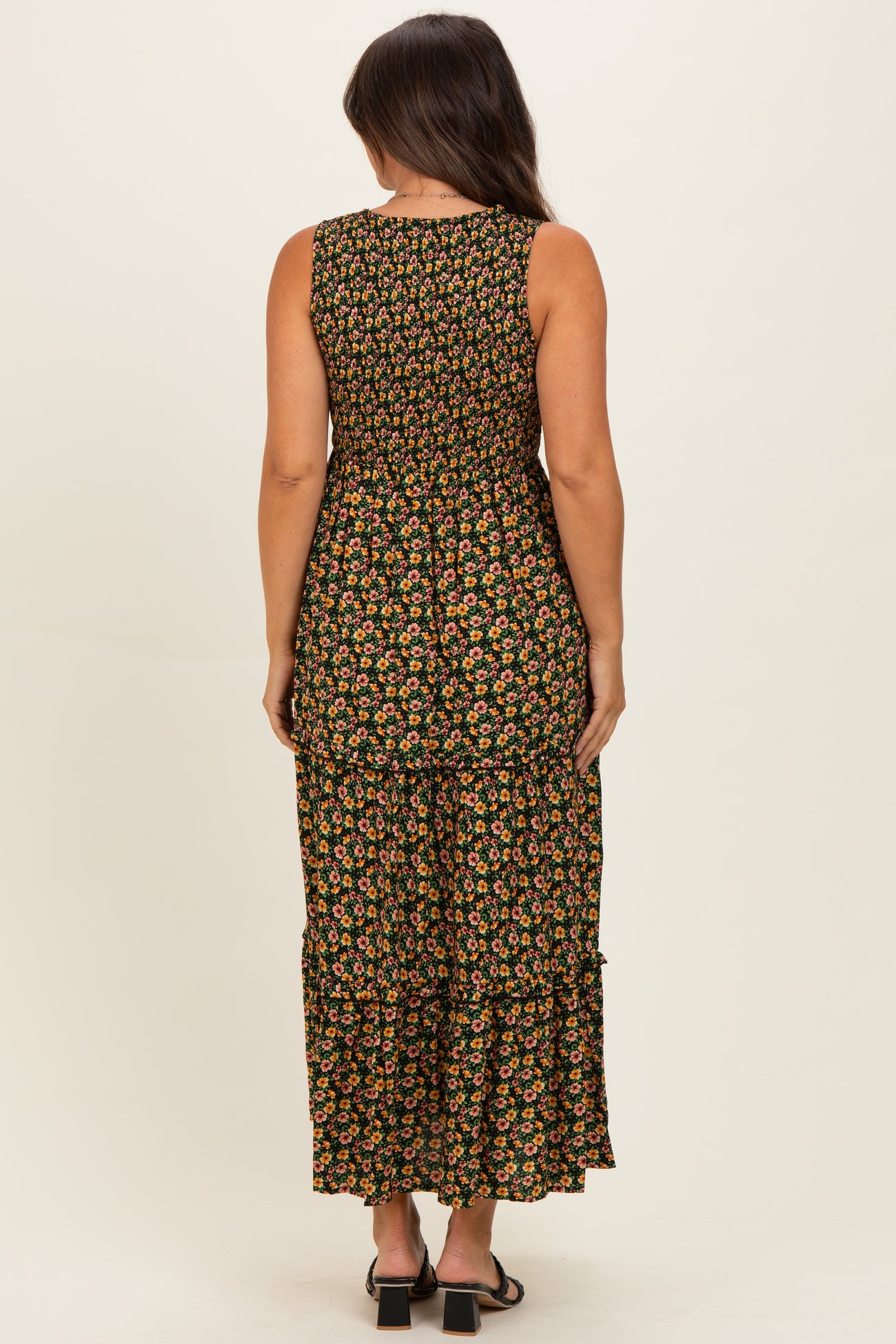woman wearing a floral maternity maxi dress with tiered detailing, showing the back view