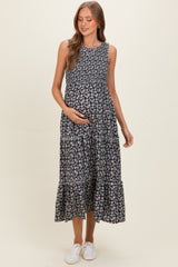 woman wearing a black floral maternity maxi dress with tiered layers and holding her baby bump