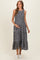 woman wearing a black floral maternity maxi dress with tiered layers and holding her baby bump