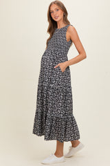 woman wearing a black floral maternity maxi dress with pockets and a visible baby bump
