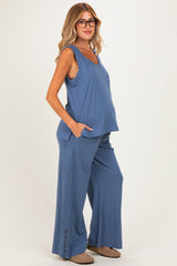 woman wearing a blue maternity tank top and matching wide-leg pants, with a visible baby bump and pockets on the pants