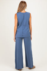 woman wearing a blue maternity top and matching wide-leg pants, showing a relaxed fit and back view