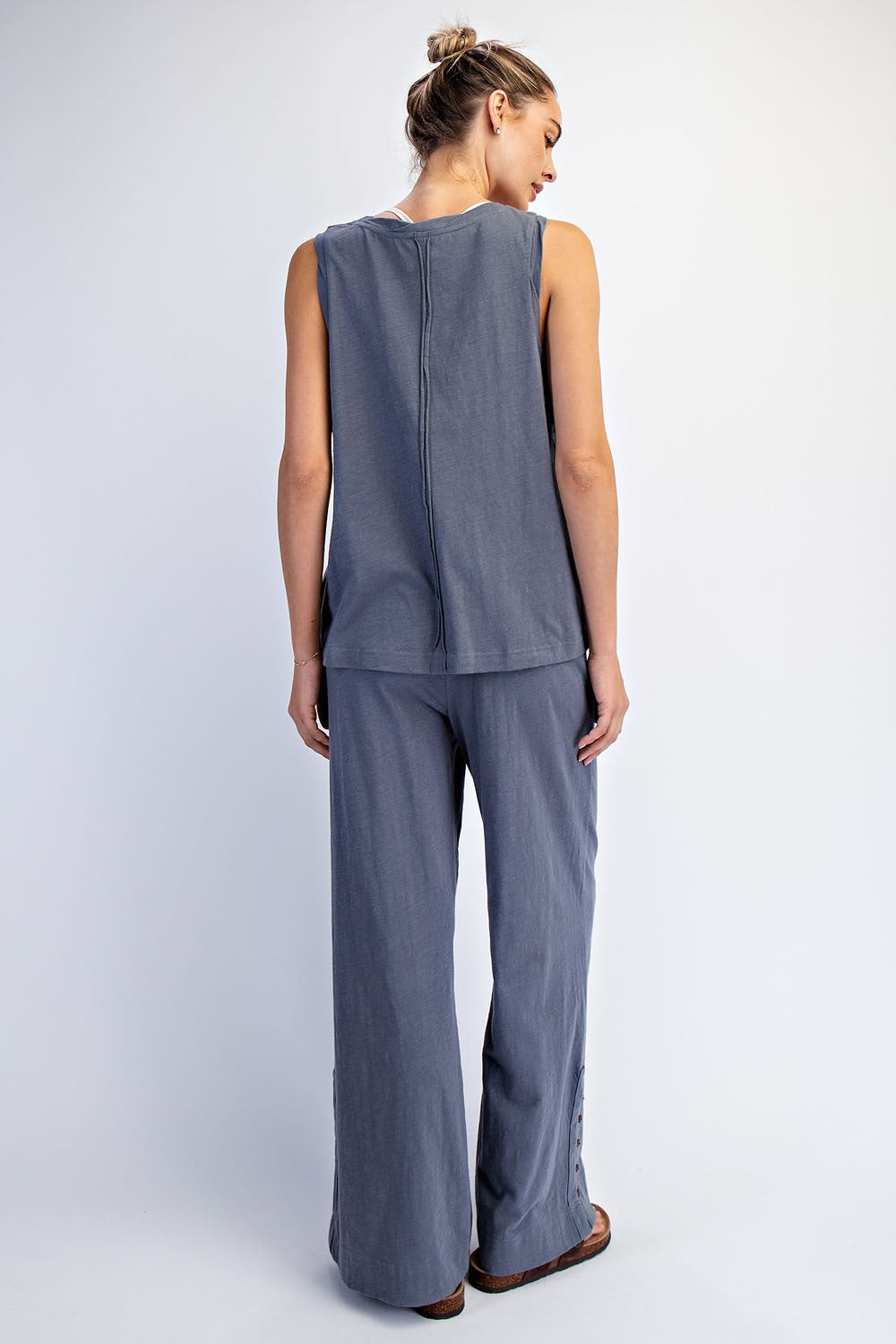 woman wearing a gray sleeveless top and matching wide-leg pants, seen from the back