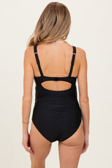 woman wearing a black maternity one-piece swimsuit with adjustable straps and an open back detail
