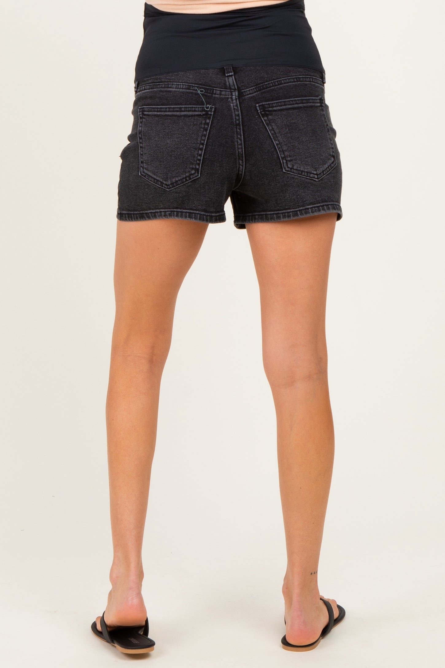 woman wearing black maternity shorts, showing the back view with a stretchy waistband