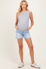woman wearing a gray sleeveless maternity tank top and light blue denim shorts, showing her baby bump