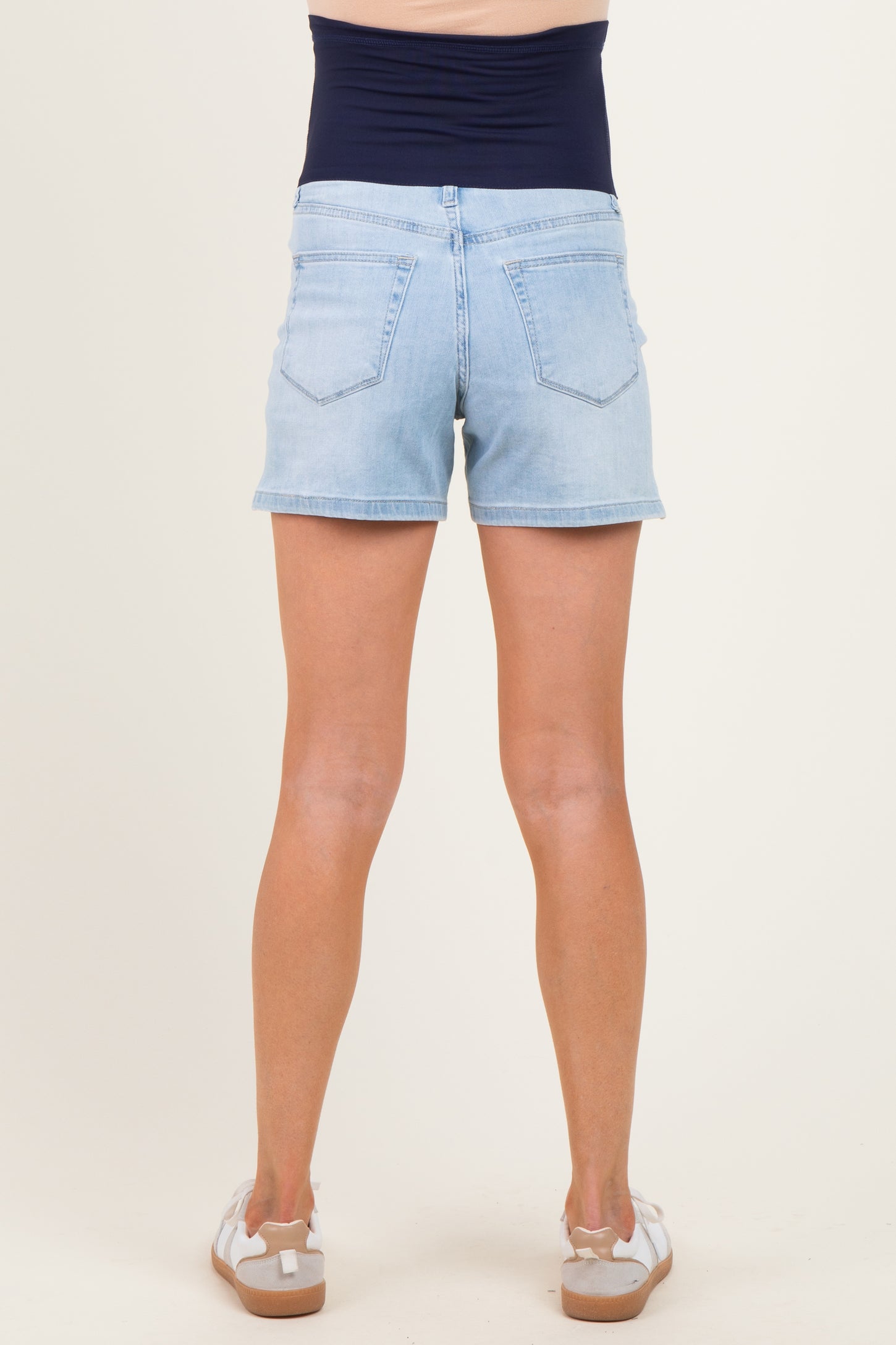 woman wearing light blue maternity shorts with a navy waistband, showing the back view