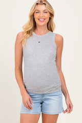woman wearing a light gray ribbed maternity tank top and denim shorts, highlighting her baby bump