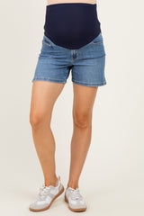woman wearing a navy blue maternity belly band denim shorts with side pockets and white sneakers