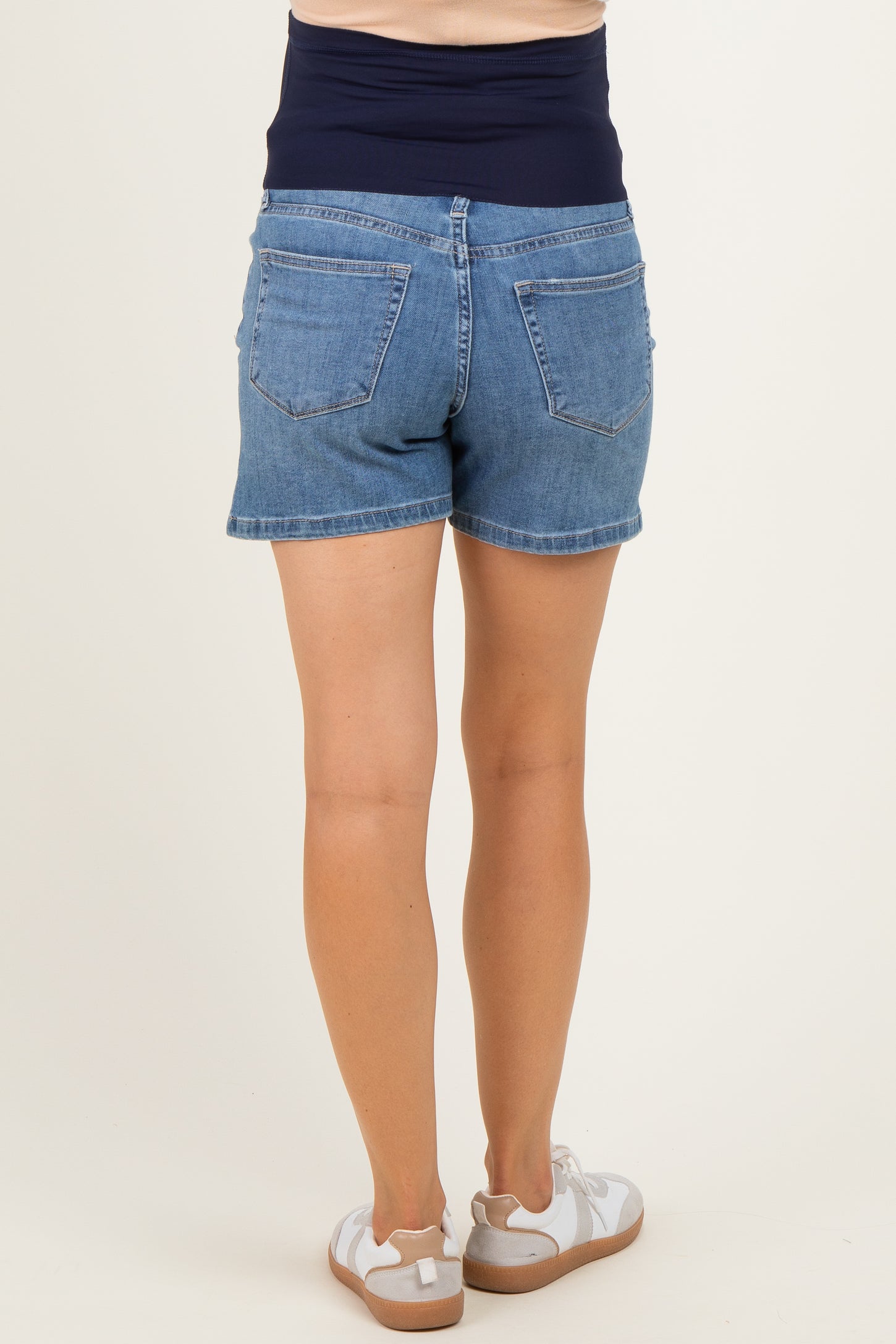 woman wearing maternity denim shorts with a foldable waistband, shown from the back