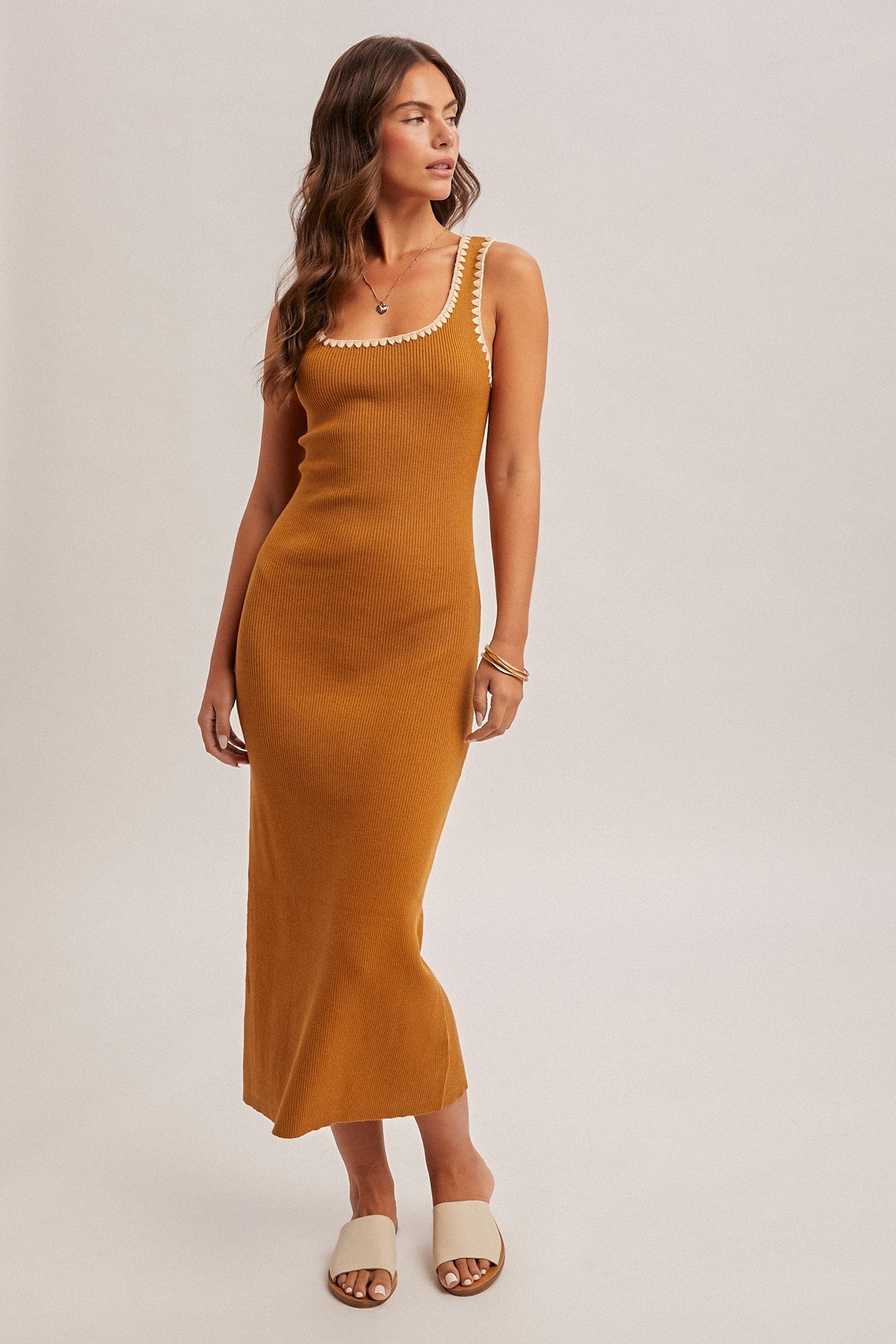 woman wearing a mustard ribbed maxi dress with a scoop neckline and decorative straps