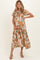 woman wearing a floral maternity dress with short sleeves and a tiered skirt, gently cradling her baby bump