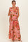 woman wearing a pink floral maternity maxi dress and holding her baby bump